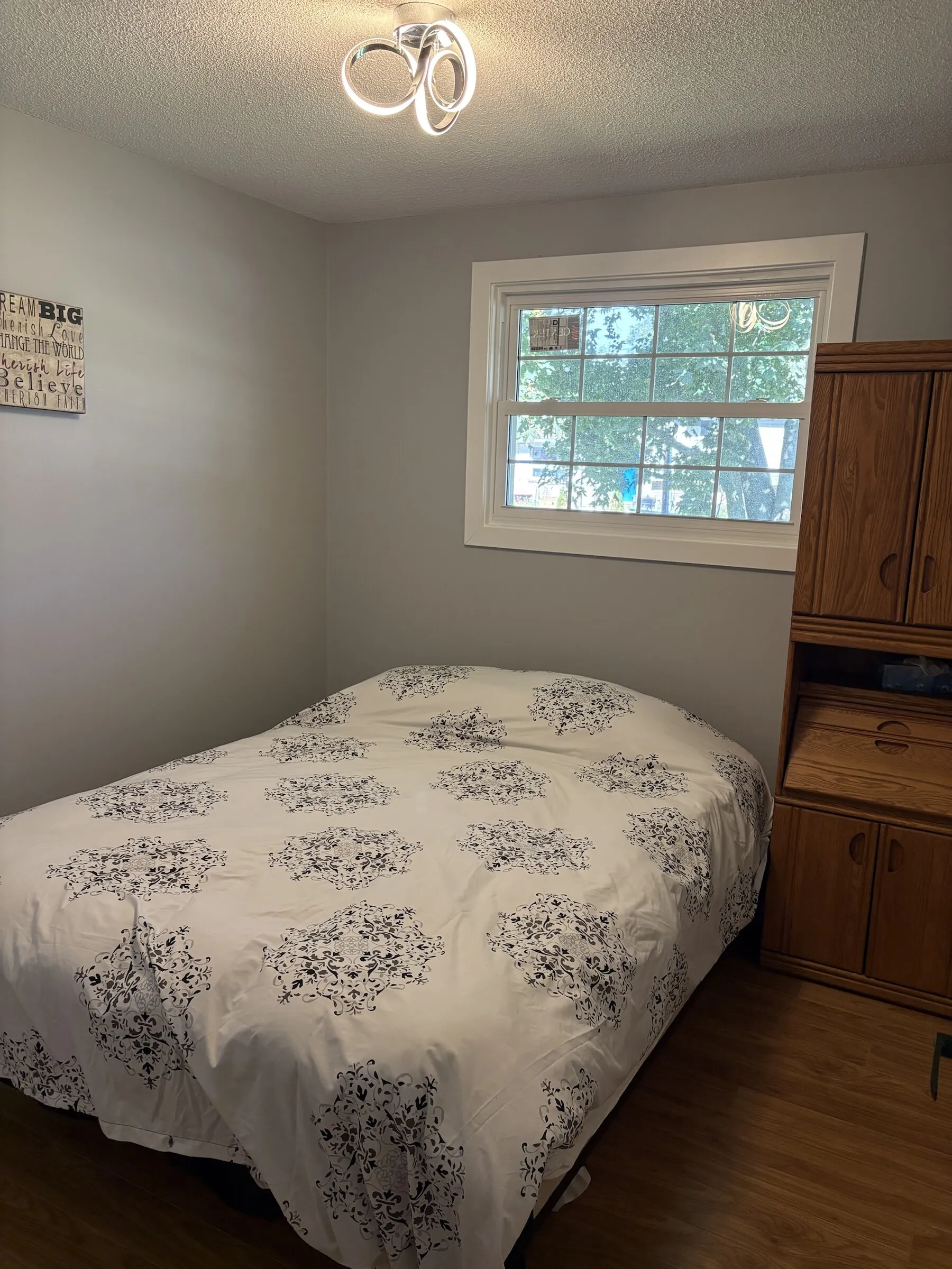Bedroom with damask duvet and window to the trees