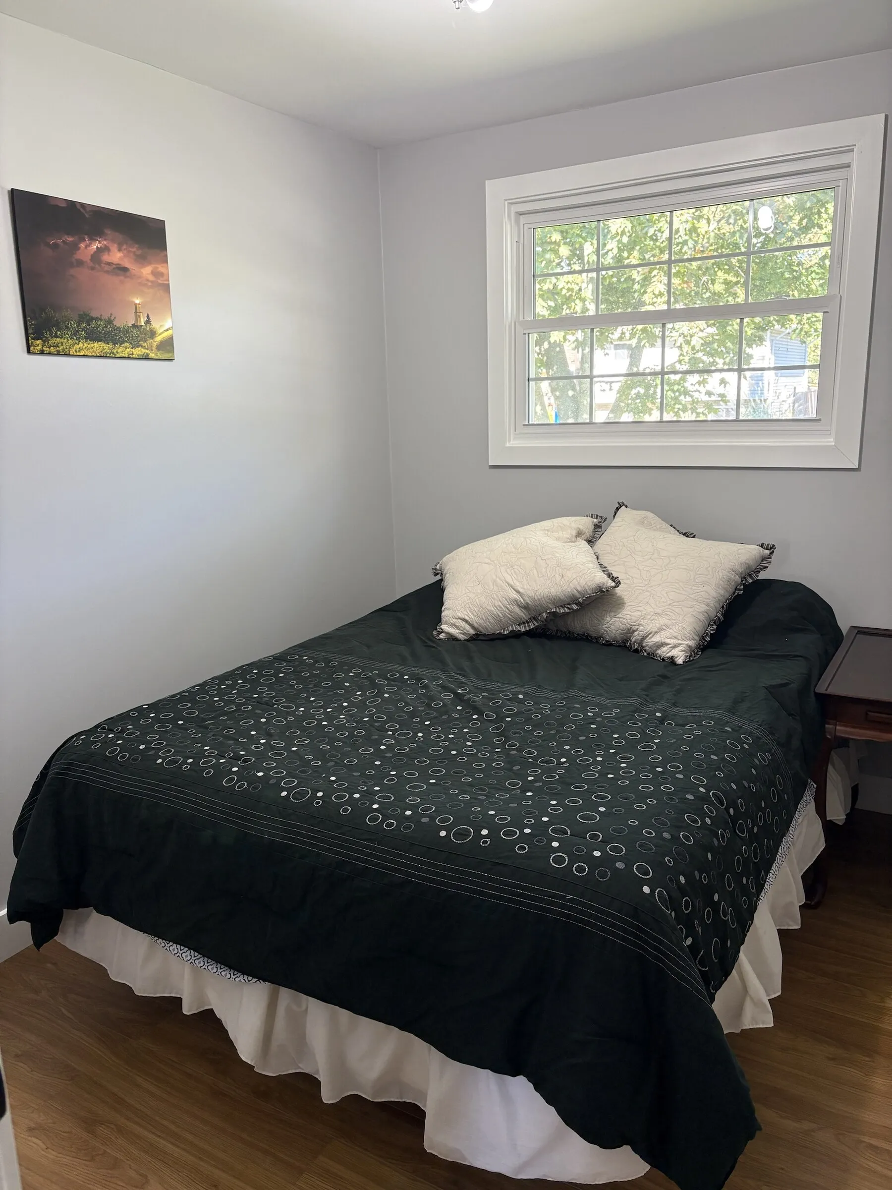 Bedroom with dark comforter and lighthouse print