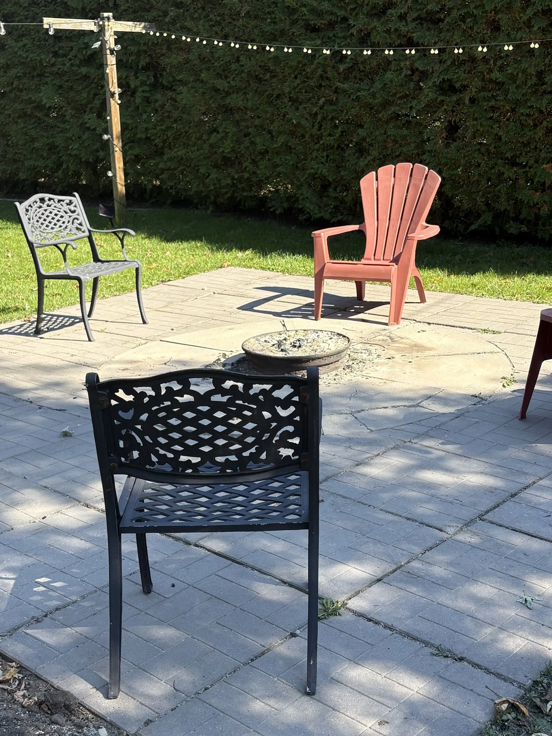 Fire pit surrounded by patio and Adirondack chairs